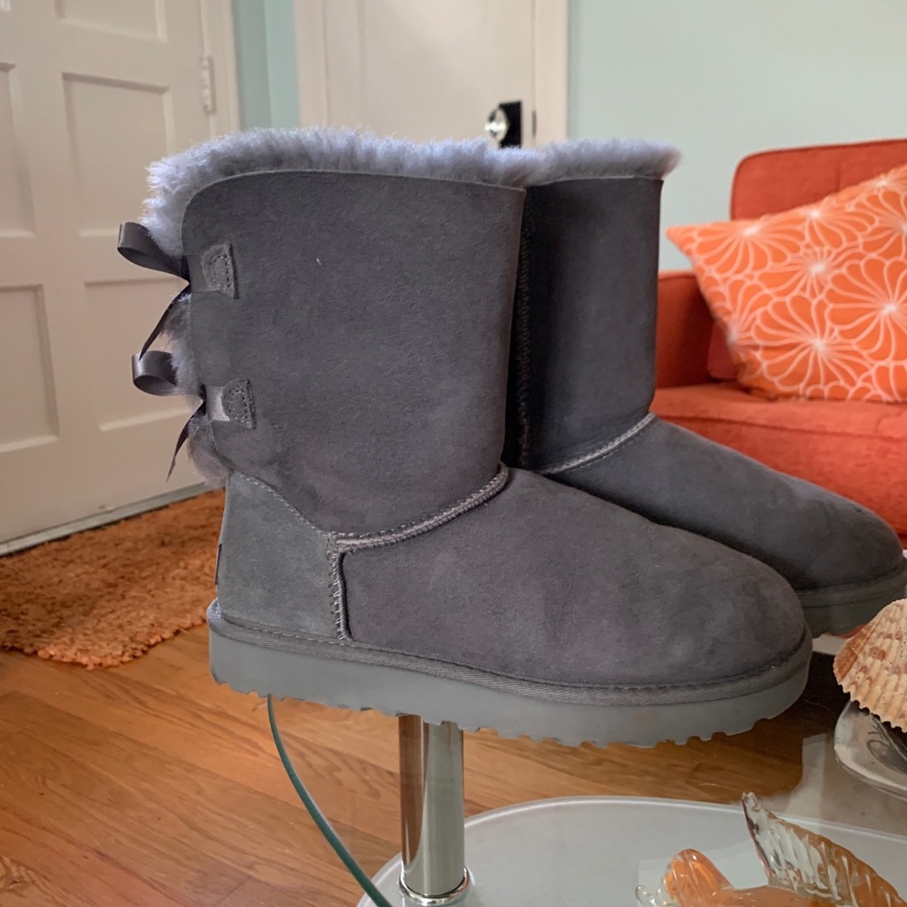 UGG Bailey Bow Boots that are a light grey color.